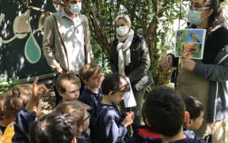 Un professeur donne un cours sur la biodiversité à un groupe d'enfants attentifs
