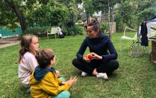 Tennis club de Paris Nelsina et des enfants assis dans l'herbe
